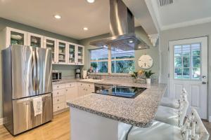 a kitchen with a stainless steel refrigerator and white cabinets at Reddington Beach Oasis with Pool, Walk to Ocean! in St Pete Beach