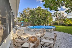 a patio with chairs and a swimming pool at Reddington Beach Oasis with Pool, Walk to Ocean! in St. Pete Beach