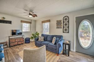 ein Wohnzimmer mit einem blauen Sofa und einem TV in der Unterkunft Lakeview Mecosta Cottage with Grill and Fire Pit in Mecosta