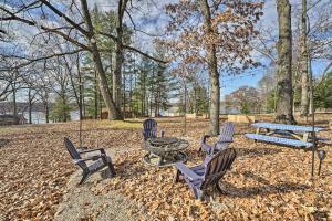a group of chairs and a picnic table in a park at Lakeview Mecosta Cottage with Grill and Fire Pit in Mecosta