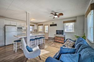 a living room with a blue couch and a kitchen at Lakeview Mecosta Cottage with Grill and Fire Pit in Mecosta