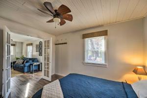Schlafzimmer mit einem blauen Bett und einem Deckenventilator in der Unterkunft Lakeview Mecosta Cottage with Grill and Fire Pit in Mecosta