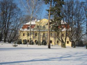 una casa antigua con nieve en el suelo en Pałac Kietlin, en Niemcza