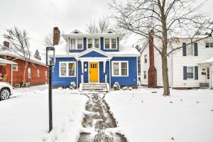 a blue house with a yellow door in the snow at South Bend Home Less Than 1 Mi to Notre Dame! in South Bend