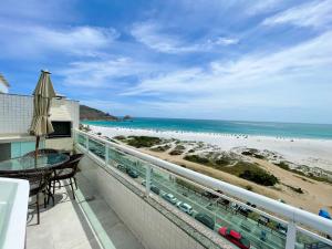 a balcony with a view of the beach at Cobertura Luxo com Jacuzzi Orla Praia Grande in Arraial do Cabo