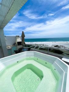 a hot tub on a balcony with the beach at Cobertura Luxo com Jacuzzi Orla Praia Grande in Arraial do Cabo