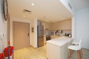 a kitchen with a white counter and a refrigerator at Yas Island - 2 Bedrooms, 2 toilet with shared Pool & Parking in Abu Dhabi