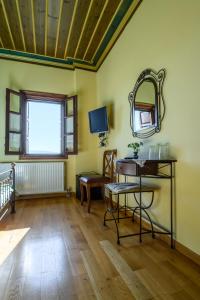 um quarto com um espelho, uma mesa e uma cadeira em Papigiotis Hotel em Tsepelovo
