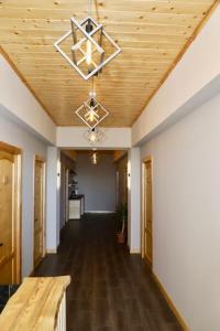 an empty hallway with a wooden ceiling and a chandelier at Sargsyan ECO house in Sevan