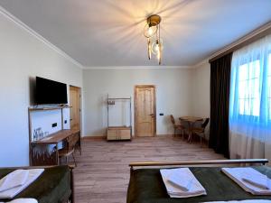 Habitación con cama, mesa y TV. en Sargsyan ECO house en Sevan