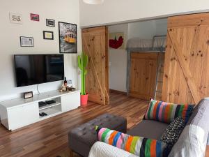ein Wohnzimmer mit einem Sofa, einem TV und einem Etagenbett in der Unterkunft BestHomeStay- Parede Beach (Lisbon) in Parede