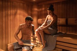 a man and a woman sitting in a sauna at Apart Relax in Längenfeld