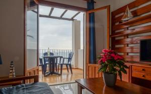 uma sala de estar com uma mesa e vista para o oceano em Aldeas Taray Admer 11 em La Manga del Mar Menor