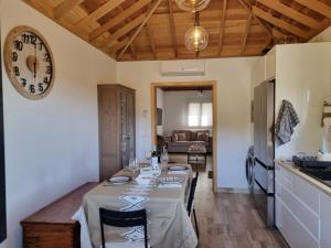 a kitchen and living room with a table and a clock at villa los vaqueros in Garafía