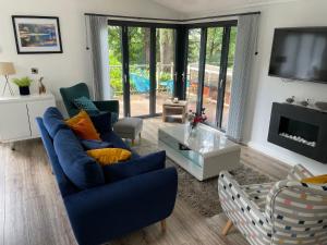 a living room with blue couches and a tv at Windermere Lodge in Bowness-on-Windermere