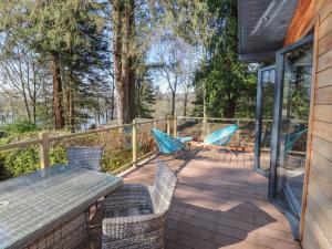 a patio with chairs and a table on a deck at Windermere Lodge in Bowness-on-Windermere