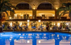 a hotel with a pool in front of a restaurant at Hotel Costa dei Fiori in Santa Margherita di Pula