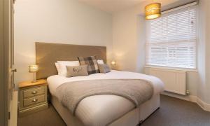 a bedroom with a large bed and a window at Hazel Cottage in Ambleside
