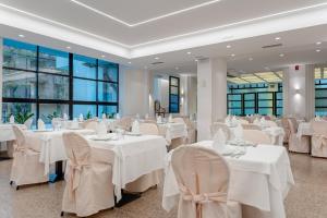 a banquet hall with white tables and chairs at Hotel Queen Mary in Cattolica