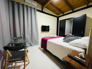 a bedroom with a bed and a table and a chair at Vila Uluwatu 1 in Florianópolis +88 photos