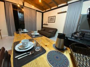 a wooden table with plates and cups on top of it at Vila Uluwatu 1 in Florianópolis