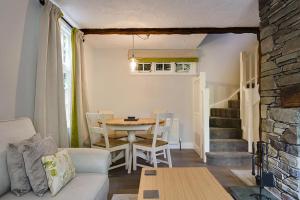 sala de estar con mesa, mesa y sillas en Acorn Cottage, en Grasmere