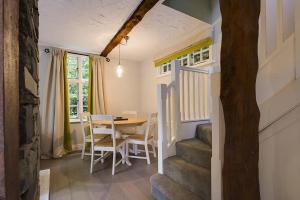 a dining room with a table and chairs and a staircase at Acorn Cottage in Grasmere