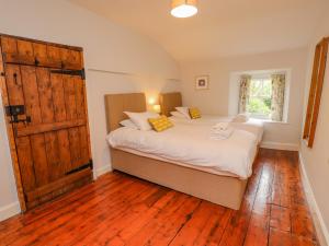 a bedroom with two beds and a large wooden door at Fir Tree Cottage in Ambleside