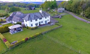 an aerial view of a white house on a green field at Hawkrigg Farm in Far Sawrey