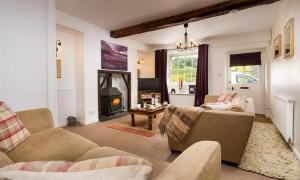 a living room with two couches and a fireplace at Pollys Cottage in Elterwater