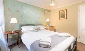 two twin beds in a room with floral wallpaper at Ghyll Foot Cottage in Ambleside
