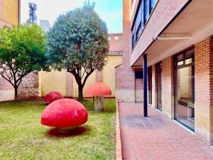 a building with red spheres in the grass next to a building at Housingleón - Palacio de Don Ramiro in León