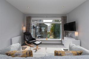 a living room with a couch and a chair and a window at Silver Howe in Grasmere