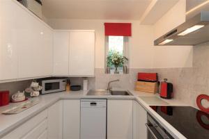 a white kitchen with a sink and a microwave at Silver Howe in Grasmere