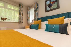 a bedroom with a large bed with yellow and blue pillows at Silver Howe in Grasmere