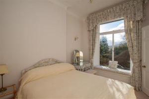 Un dormitorio blanco con una cama y una ventana. en Betamere, en Ambleside