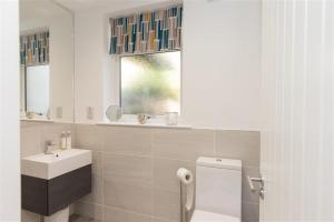 a bathroom with a sink and a toilet and a window at Silver Howe in Grasmere +6 photos