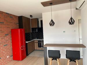a kitchen with a red refrigerator and two bar stools at Arena ZG Apartment in Zagreb