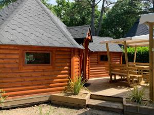 une cabine avec une terrasse en bois et un banc dans l'établissement Team Holiday - Camping de l'Etang du Pays Blanc, à Guérande