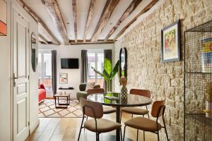 a living room with a table and chairs at Edgar Suites Montorgueil - Caire in Paris