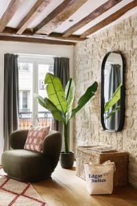 a living room with a green chair and a mirror at Edgar Suites Montorgueil - Caire in Paris