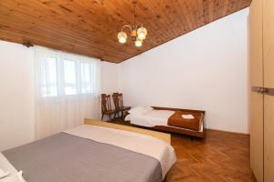 een slaapkamer met 2 bedden en een houten plafond bij Apartments Nena in Tribunj