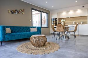 a living room with a blue couch and a table at Villa L'Alba BASTIA by Location-tourisme-corse in Bastia