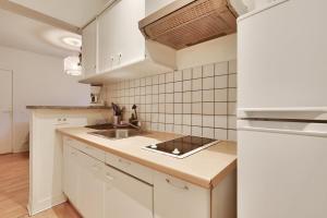 a kitchen with white cabinets and a sink at Appartement pour 4 personnes à Bagneux in Bagneux