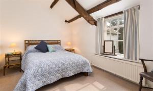a bedroom with a bed and a window at Camellia Cottage in Crook