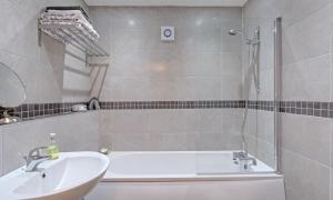 a bathroom with a bath tub and a sink at Wheatlands Cottage in Windermere +13 photos