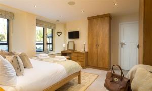 a bedroom with a bed and a dresser with a television at Deer Wood at Applethwaite Hall in Windermere