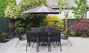 uma mesa com cadeiras pretas e um guarda-sol em Bowderstone em Keswick