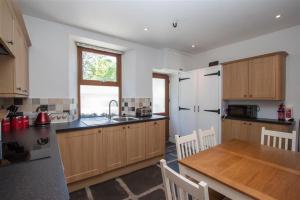 a kitchen with wooden cabinets and a wooden table at Robins Nest in Coniston