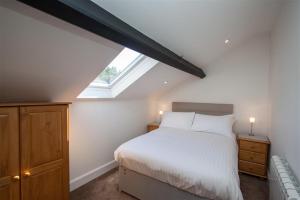 um quarto com uma cama branca e uma janela em Robins Nest em Coniston